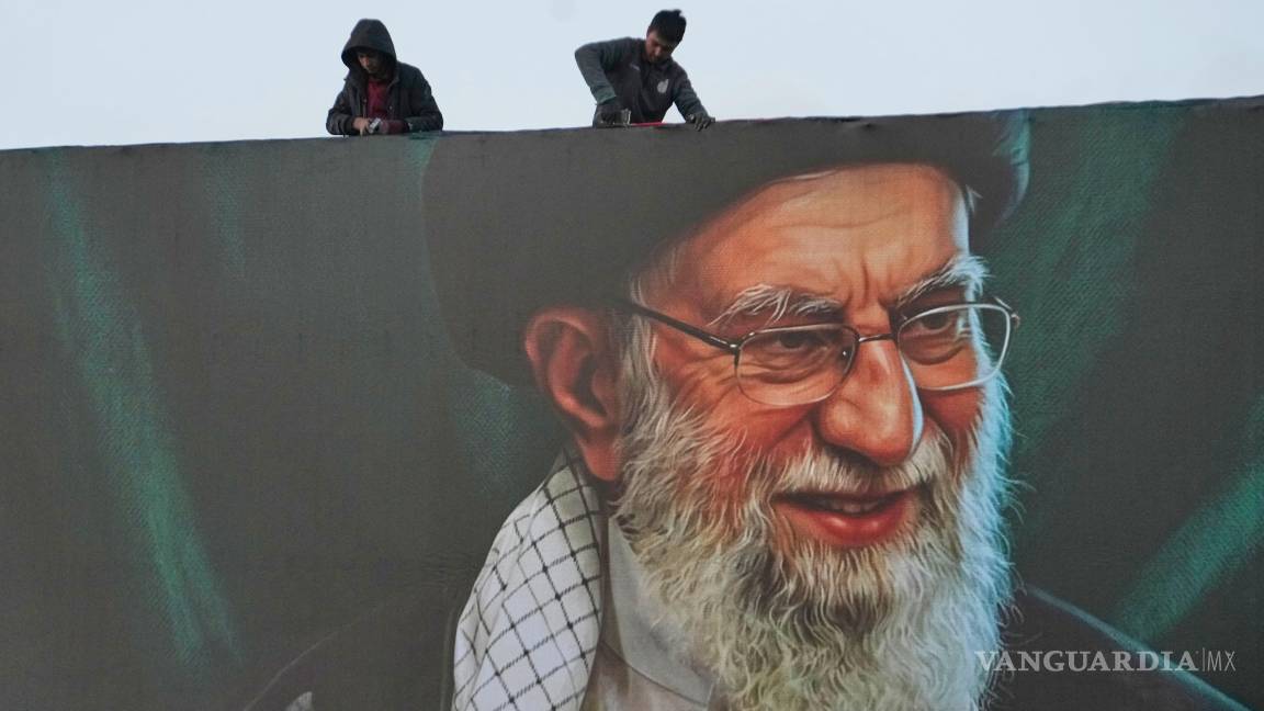 $!Trabajadores instalan una valla publicitaria en un paso elevado con un retrato del difunto líder supremo iraní, el ayatolá Ali Khamenei en Teherán, Irán.