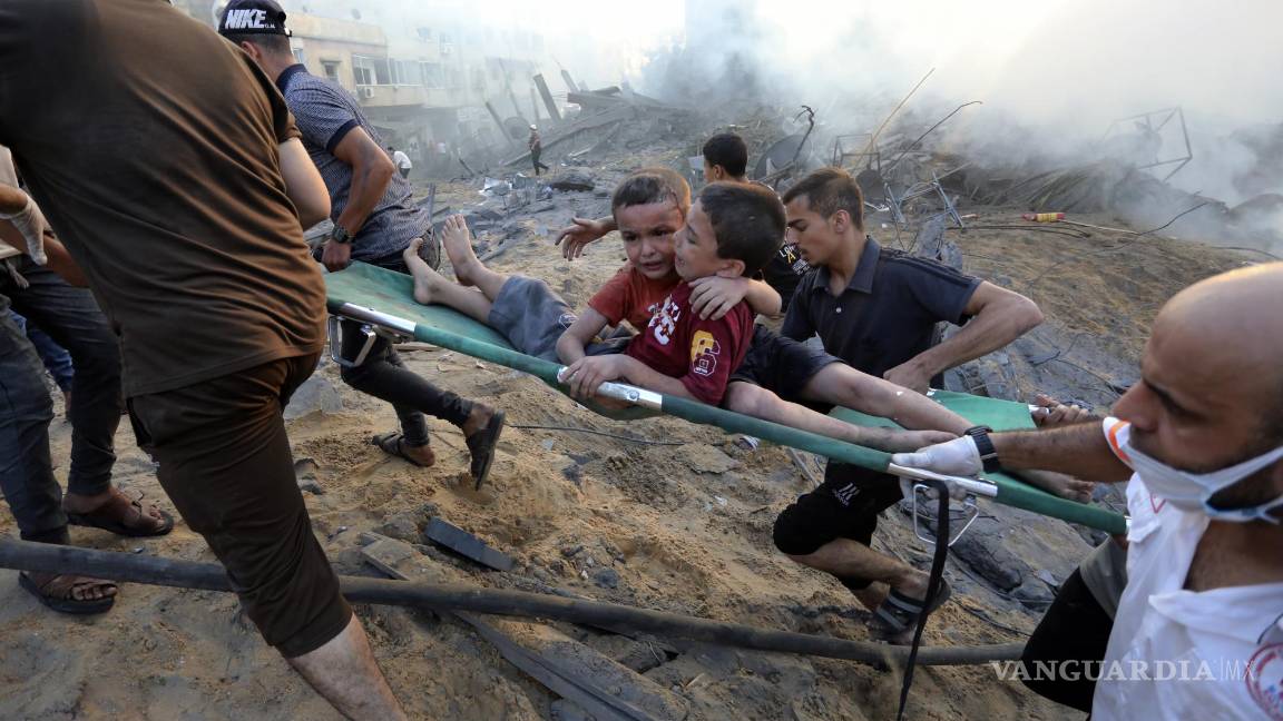 $!Palestinos sacan a dos niños heridos en un ataque aéreo israelí sobre la Ciudad de Gaza, el 25 de octubre de 2023.