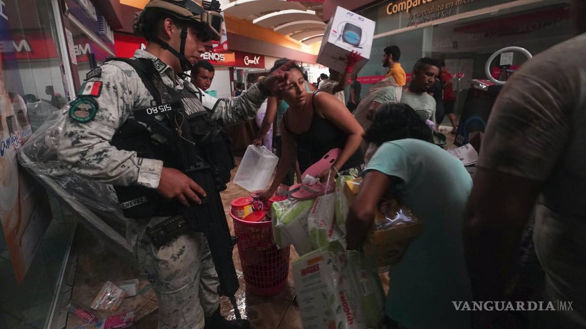$!Un militar de la Guardia Nacional intenta impedir que personas se lleven productos de las tiendas de un centro comercial en Acapulco, Guerrero (México).