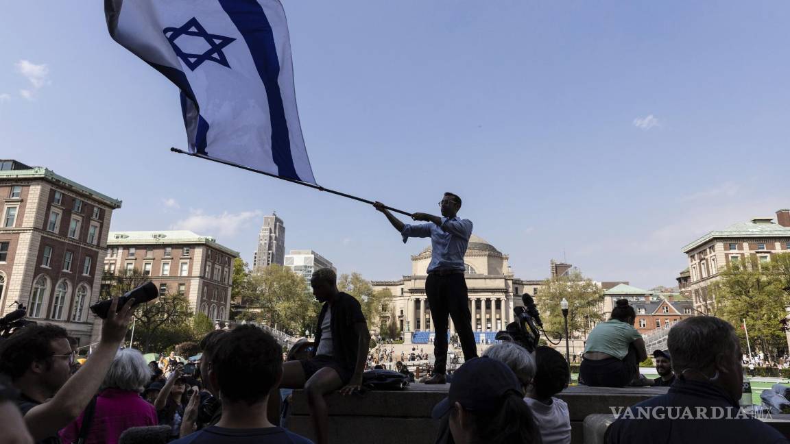 $!David Lederer, estudiante de segundo año de Columbia, ondea una gran bandera de Israel frente al campamento de protesta estudiantil en la Universidad de Columbia