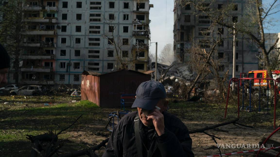 $!Mucola Markovich, de 76 años, se limpia una lágrima; al fondo un edificio residencial gravemente dañado por un ataque ruso en Zaporizhzhia, Ucrania.