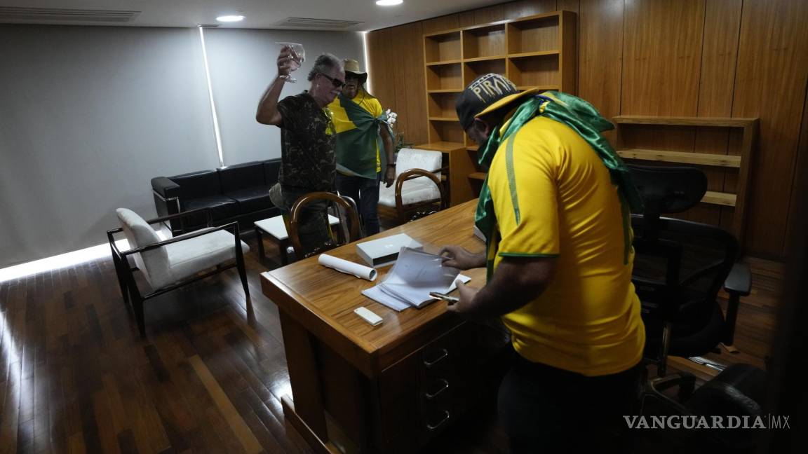 $!Los manifestantes, partidarios del expresidente de Brasil, Jair Bolsonaro, revisan papeles en un escritorio después de asaltar el Palacio Planalto en Brasilia, Brasil.