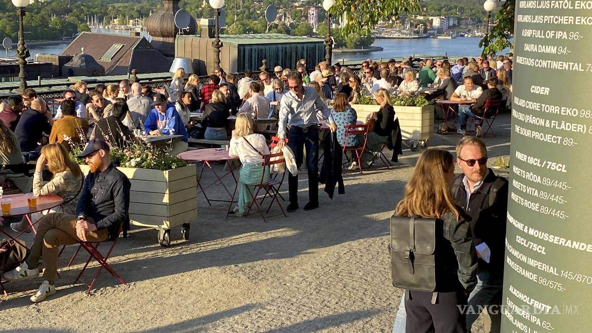 $!People enjoy drinks and snacks in the evening sun on a terrace overlooking Stockholm, Tuesday, May 30, 2023. Smoking is prohibited in both indoor and outdoor areas of bars and restaurants in Sweden, which has the lowest share of smokers in the European Union. (AP Photo/Karl Ritter)