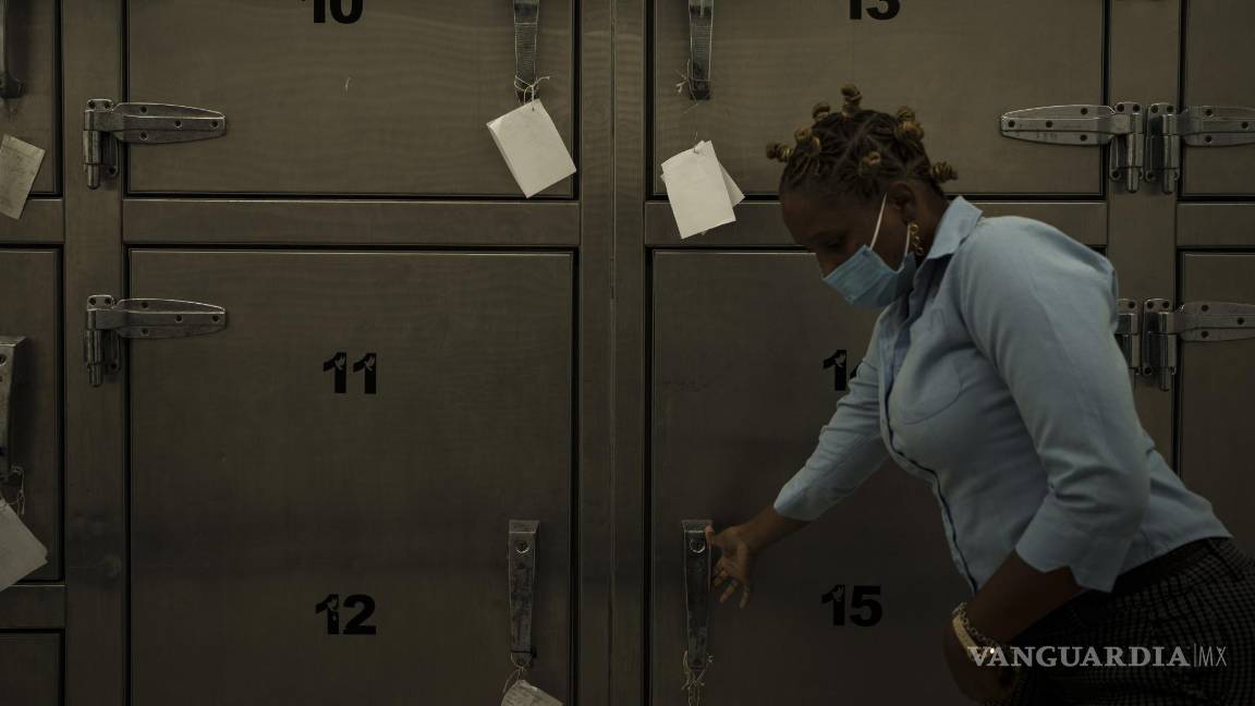 $!Una técnica forense abre la puerta de una cámara frigorífica donde se guardan los restos mortales de los migrantes que iban a bordo de un cayuco mauritano.