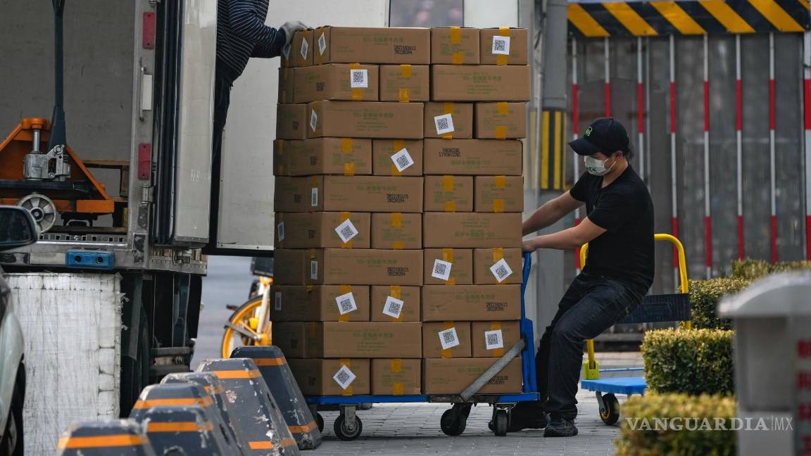 $!Los trabajadores descargan cajas que contienen carne congelada de un camión para un restaurante en un centro comercial en Beijing el 27 de febrero de 2023.