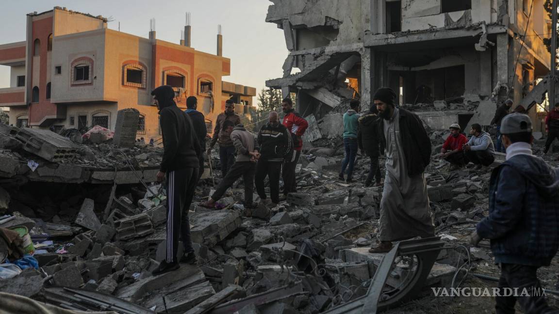 $!Palestinos buscan a sobrevivientes de un bombardeo aéreo israelí, cerca del campo de refugiados en Al Nusairat.