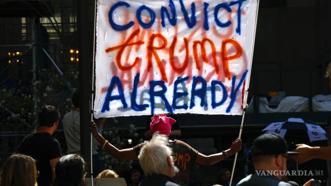 $!Una mujer sostiene una pancarta frente al tribunal penal de Nueva York el primer día del juicio contra Donald Trump en Nueva York.