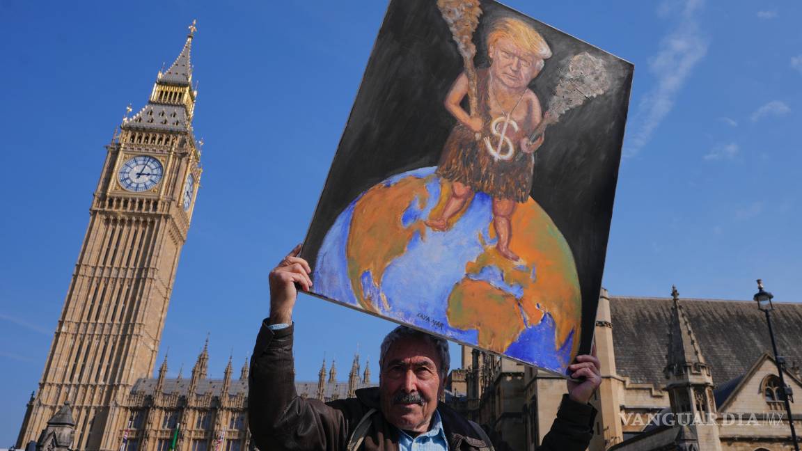 $!El artista Kaya Mar con su pintura crítica del presidente estadounidense Donald Trump en Westminster, Londres.