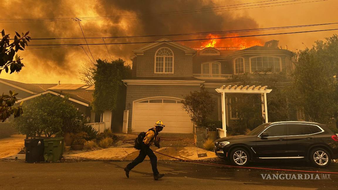 $!Una residencia en llamas mientras un bombero combate un incendio en Pacific Palisades, el martes 7 de enero de 2025, en Los Ángeles.