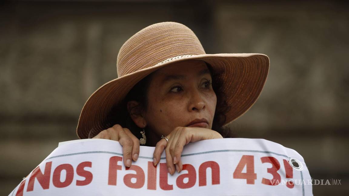 $!Una mujer lleva una pancarta que hace referencia a los 43 estudiantes desaparecidos durante una marcha el jueves 26 de noviembre de 2015 en CDMX.