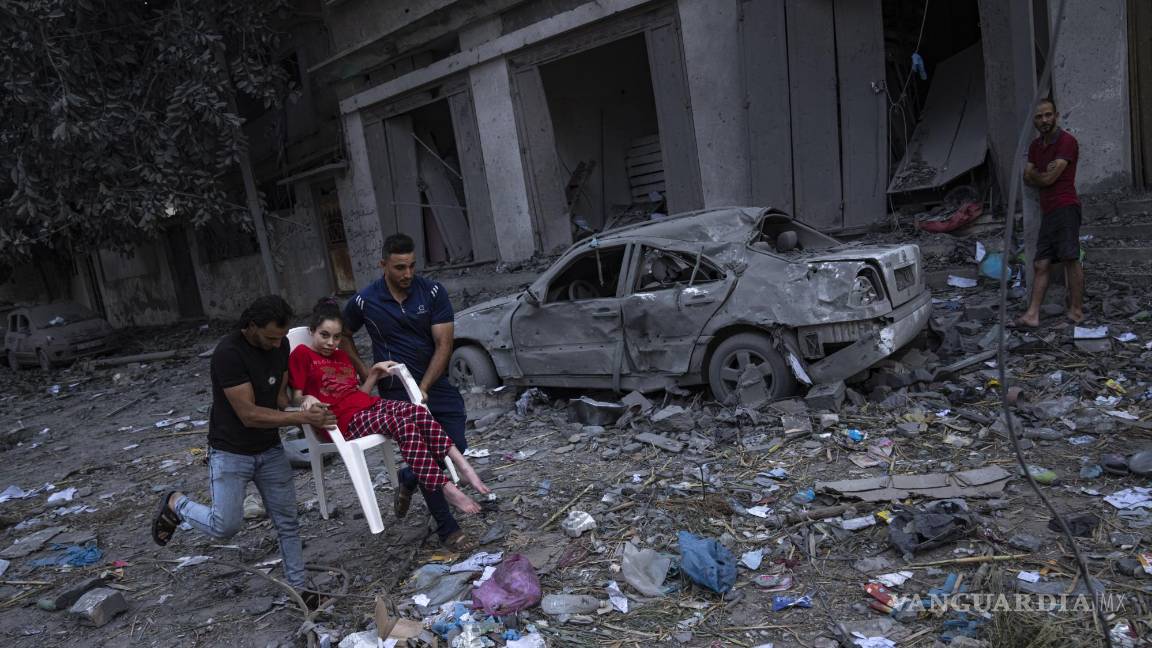 $!Palestinos caminan entre escombros luego de ataques israelíes contra una extensa zona de un vecindario en la Ciudad de Gaza, el martes 10 de octubre de 2023. Hamas, el grupo islamista que gobierna la Franja de Gaza, llevó a cabo un ataque sin precedentes el sábado contra Israel, en donde mató a más de 1.000 personas y secuestró a varias más. Israel respondió con intensos ataques aéreos contra el territorio que dejaron a cientos de palestinos muertos. (AP Foto/Fatima Shbair)