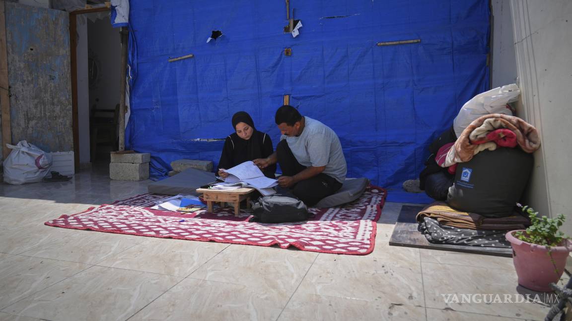 $!Sarah Qanan estudia con su padre, Ibrahim, en la tienda de campaña de su familia en Khan Younis, Franja de Gaza.