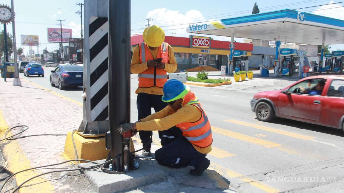 $!Trabajadores del Municipio colocan la postería donde serán instalados los semáforos inteligentes.