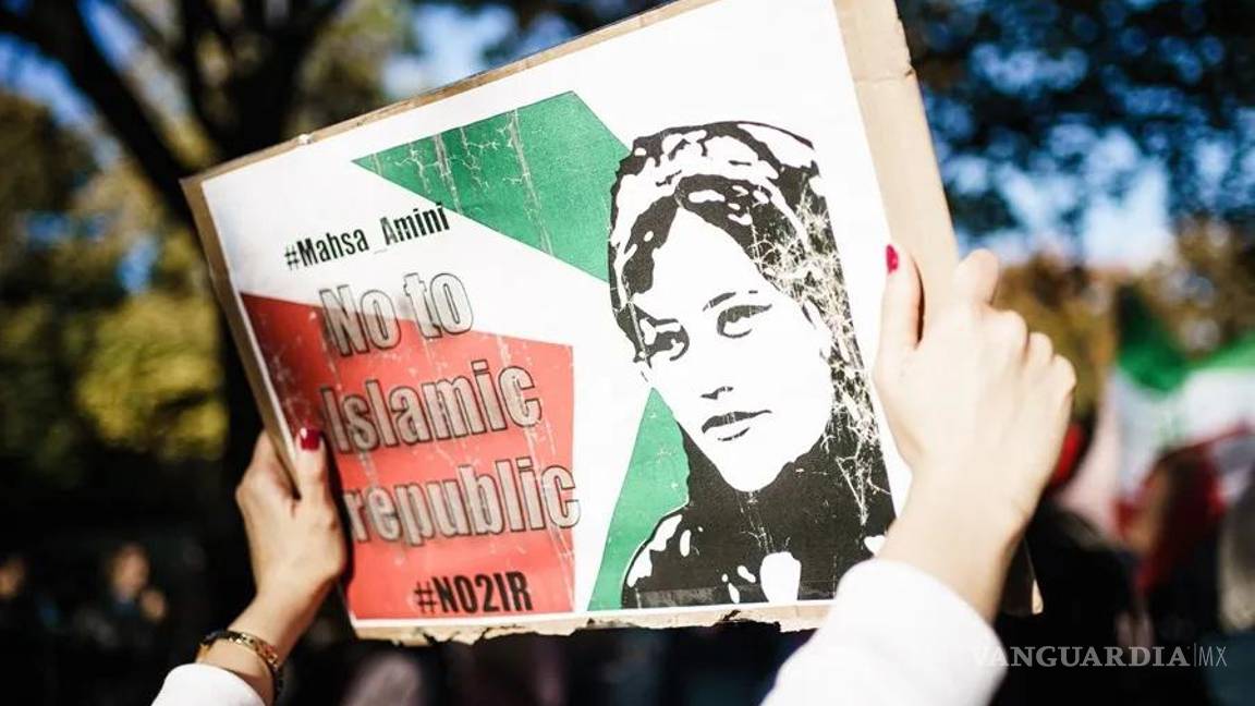 $!Una mujer muestra una imagen de la iraní Mahsa Amini en una concentración.