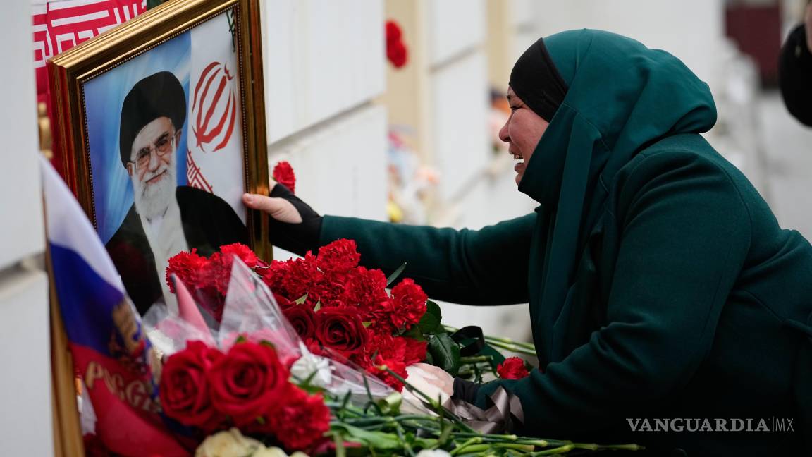 $!Una mujer tayika llora mientras toca un retrato del líder supremo iraní, el ayatolá Ali Khamenei, en la embajada de Irán en Moscú.
