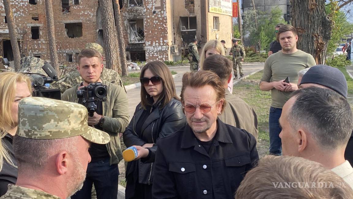 $!El músico irlandés de la banda U2, Bono (c), durante su visita este domingo en la localidad ucraniana de Irpin.