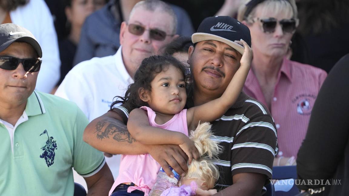 $!El sobreviviente del tiroteo masivo Wilson García sostiene a una niña durante una vigilia por su hijo, Daniel Enrique Laso, en Cleveland, Texas.