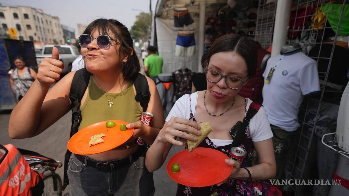 $!Una mujer levanta el pulgar mientras come un taco de la taquería Tacos El Califa de León en Ciudad de México.