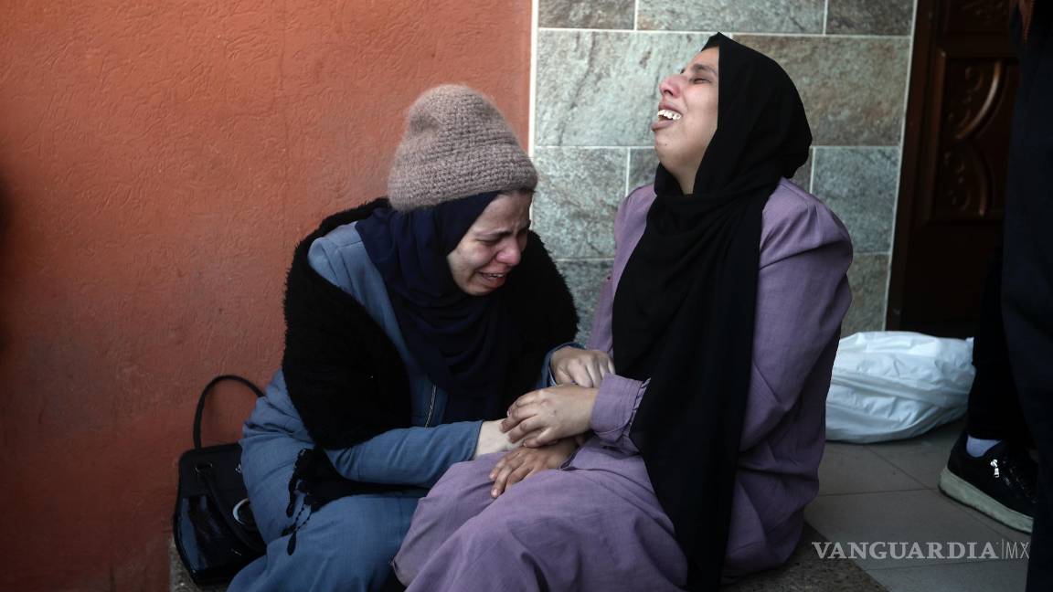 $!Dos mujeres palestinas lloran a sus familiares fallecidos en un bombardeo israelí sobre la Franja de Gaza, en el exterior de una morgue en Jan Yunis.