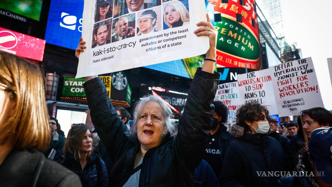 $!Una mujer con una pancarta con imágenes de Donald Trump y miembros de su gabinete durante una protesta contra los ataques de EU contra Irán, en Nueva York.