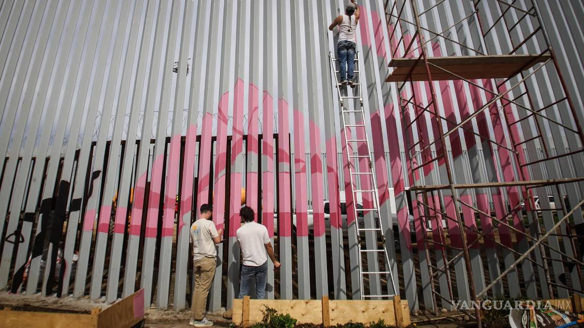 $!Artistas pintan con colores el nuevo muro instalado en la frontera con Estados Unidos para protestar por la renovación de la pared y por la crisis migratoria que se vive en la zona este sábado, en Tijuana.