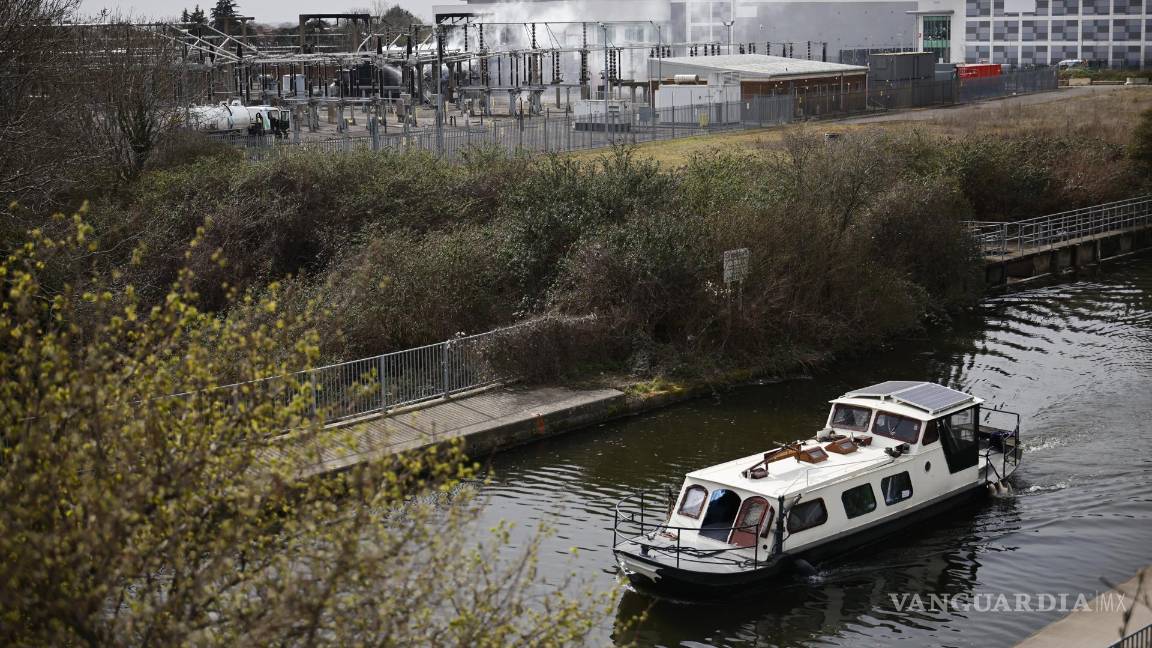 $!Un barco pasa por el canal mientras el humo se eleva desde la subestación eléctrica de North Hyde que se incendió en Londres, Gran Bretaña.