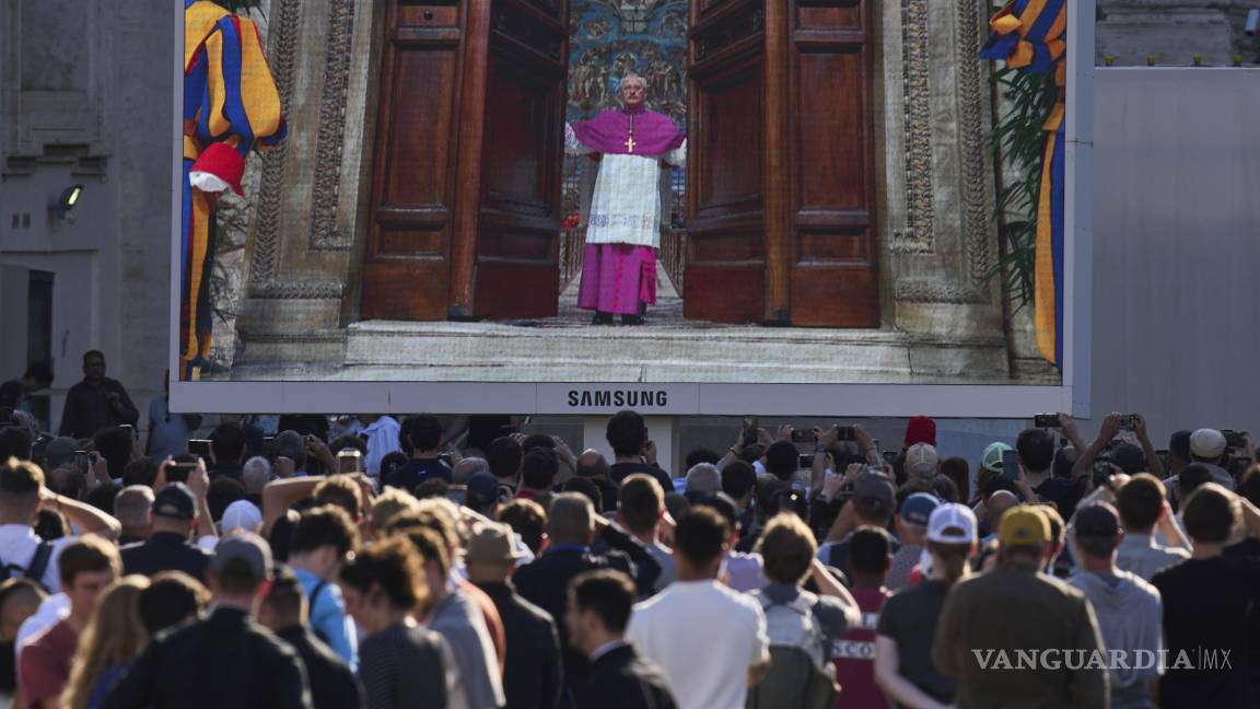$!Personas observan en una pantalla a un funcionario del Vaticano cerrando la puerta de la Capilla Sixtina tras gritar “extra omnes” (latín: “todos fuera”).