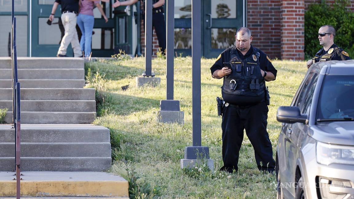 $!Policías afuera de la escuela secundaria Henryetta, cuando la gente llega para una vigilia en homenaje a las siete personas encontradas muertas en Okmulgee.