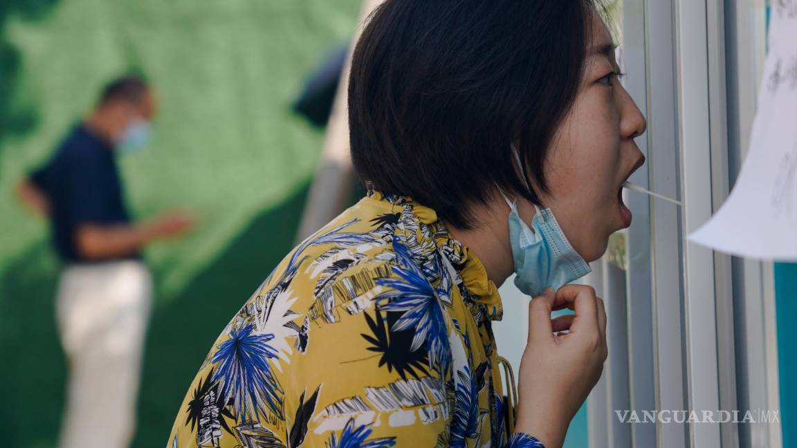 $![Beijing (China), 15/09/2022.- A medical worker takes a swab sample from a woman in Beijing, China]