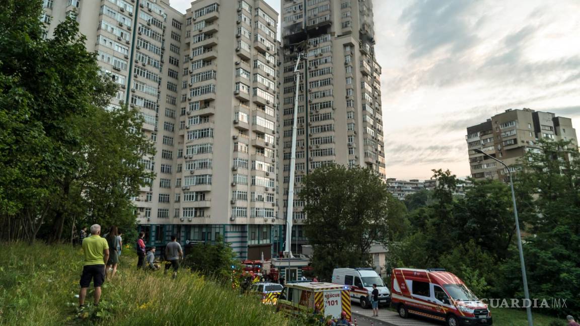 $!Los residentes y los servicios de emergencia se reunieron frente a un edificio residencial de gran altura que fue alcanzado por un misil en Kiev, Ucrania.