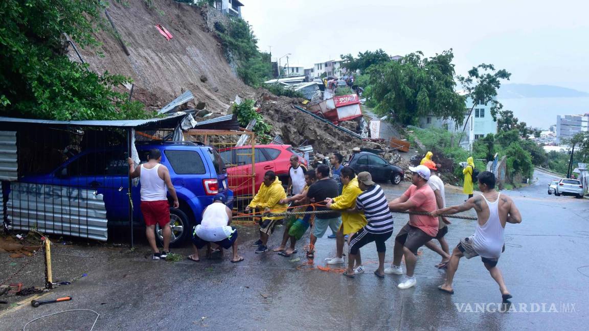 $!Un gran deslave provocado por el reblandeciendo de tierra por las lluvias constantes que dejo el huracán John, afectó a seis vehículos y pone en riesgo a cuatro edificios.