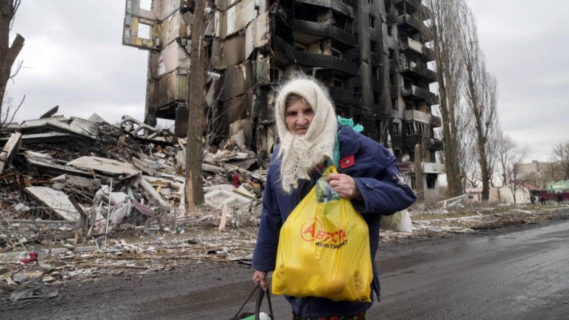 $!Una anciana camina frente a un edificio de apartamentos destruido por el bombardeo ruso en Borodyanka, Ucrania.