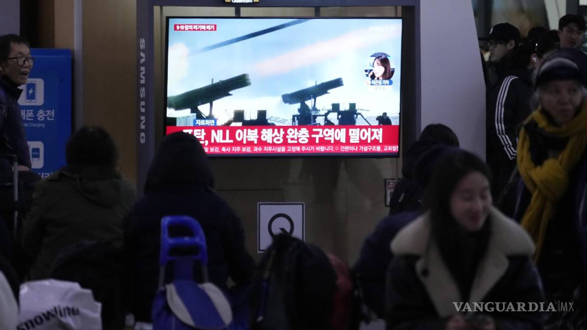 $!En una estación de trenes, ciudadanos de Corea del Sur observan por TV la noticia de los ejercicios militares con fuego real.