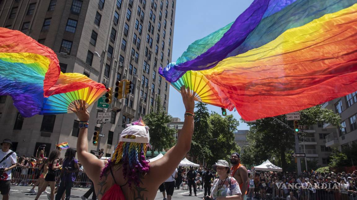 $!Una persona con abanicos de arcoíris marcha para celebrar a la comunidad LGBTQ+ durante la Marcha del Orgullo en Nueva York.
