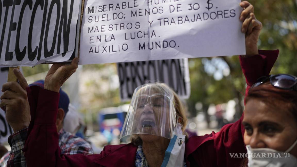 $!Una mujer sostiene un cartel durante una protesta en reclamo de un aumento en las pensiones en medio de una inflación récord mundial en Caracas, Venezuela, el 15 de febrero de 2022.