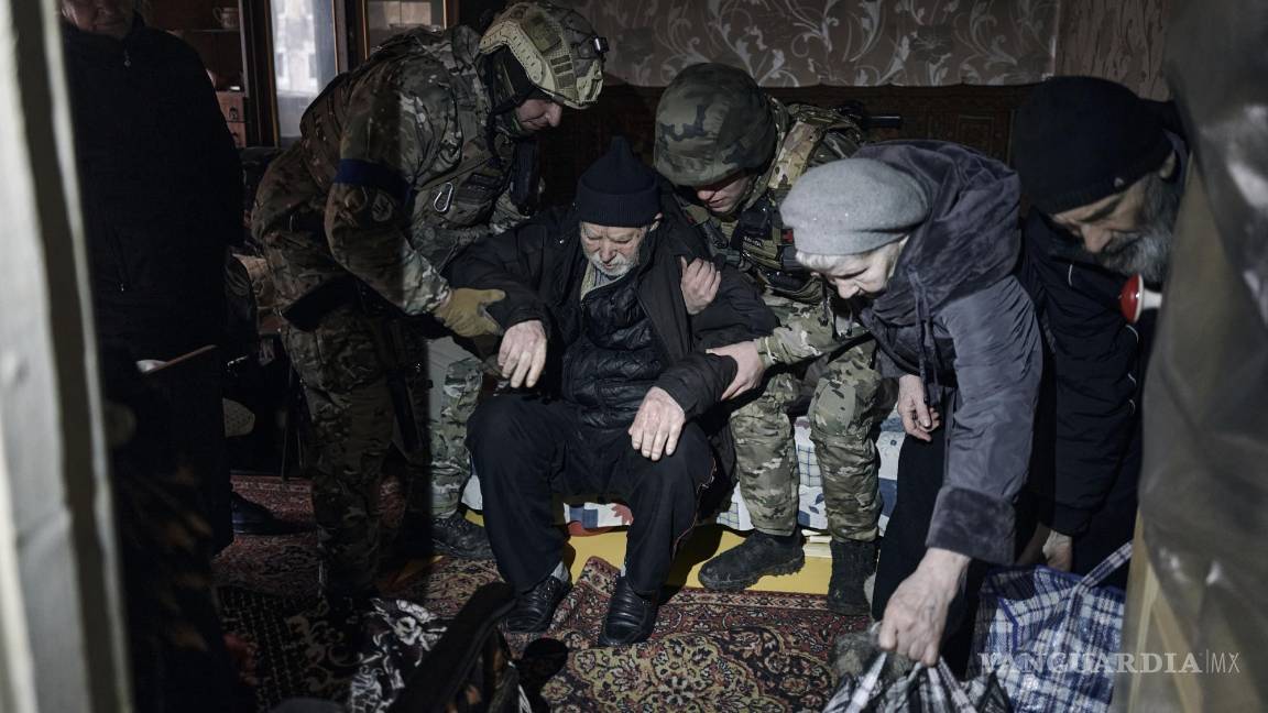 $!Agentes de policía ayudan a un anciano residente discapacitado a entrar en un coche de evacuación en Avdiivka, región de Donetsk, Ucrania.