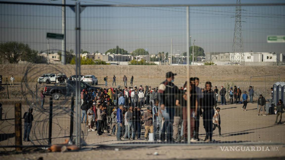 $!Migrantes hacen fila en un campamento de migrantes para ser registrados por agentes de la Patrulla Fronteriza antes de ser procesados en El Paso, Texas.