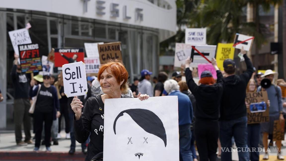 $!Manifestantes asisten a una protesta contra de Tesla frente a una sala de exposición de Tesla en Santa Mónica, California.