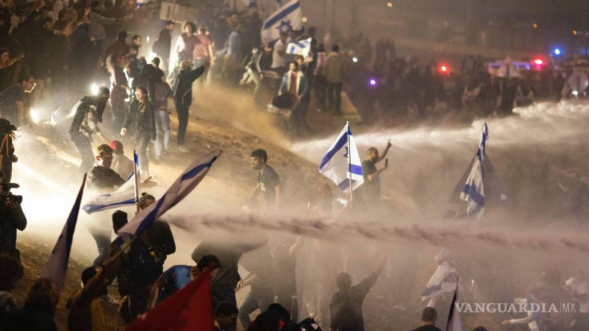 $!Policías israelíes emplean un cañón de agua para dispersar a los manifestantes que cortan una autopista en Tel Aviv, Israel.