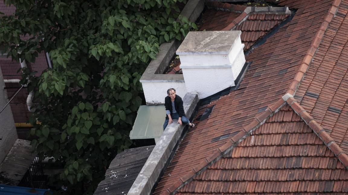 $!Un hombre se sienta en el techo de su casa en un complejo residencial en Shanghái, China.