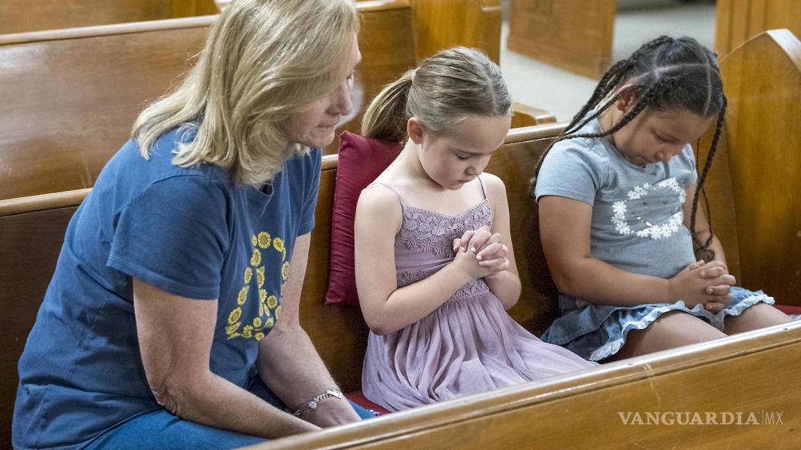 $!Layne Collis se sienta a orar con su nieta, Karsyn Collis (d), y su amiga, Ellie Barrosos, de 7 años (c), en la Iglesia Bautista Hunt en Hunt, Texas.