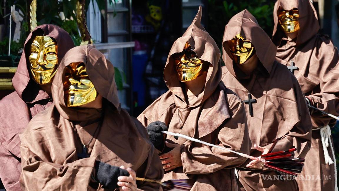 $!Los penitentes católicos que se autoflagelan llevan máscaras de color dorado mientras recorren las comunidades para celebrar el Viernes Santo en Kalayaan.
