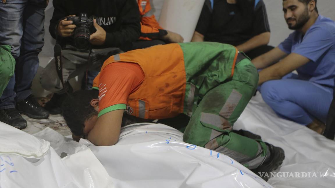 $!Elementos de protección civil palestinos lloran por la muerte de uno de sus colegas durante un bombardeo israelí.