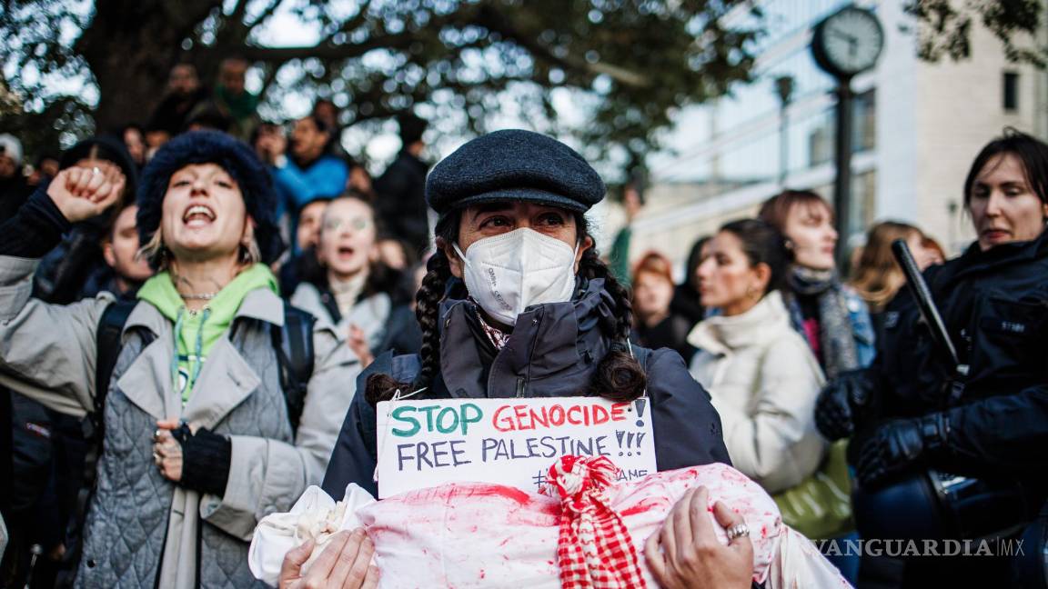 $!Un activista sostiene un objeto vestido con una tela blanca coloreada con pintura roja y un cartel que dice “Alto al genocidio - Palestina libre” en Berlín, Alemania.
