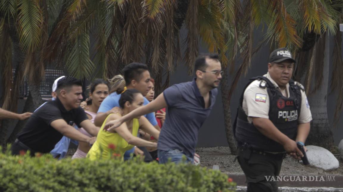 $!La policía evacúa a personal del canal TC Televisión después de que un grupo armado y encapuchado irrumpiera en plena transmisión en directo, en Guayaquil.