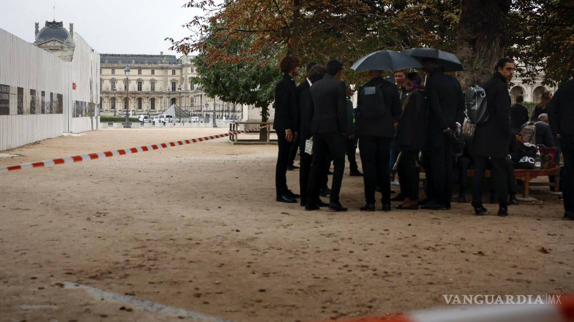$!Empleados esperan después de la evacuación del Museo de Louvre en París, el sábado 14 de octubre de 2023.