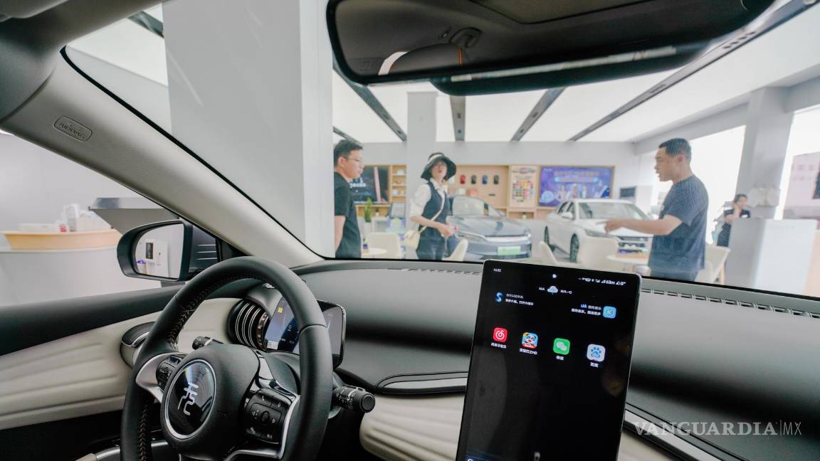 $!La gente mira un automóvil eléctrico BYD en una sala de exposición de BYD en Beijing, China.