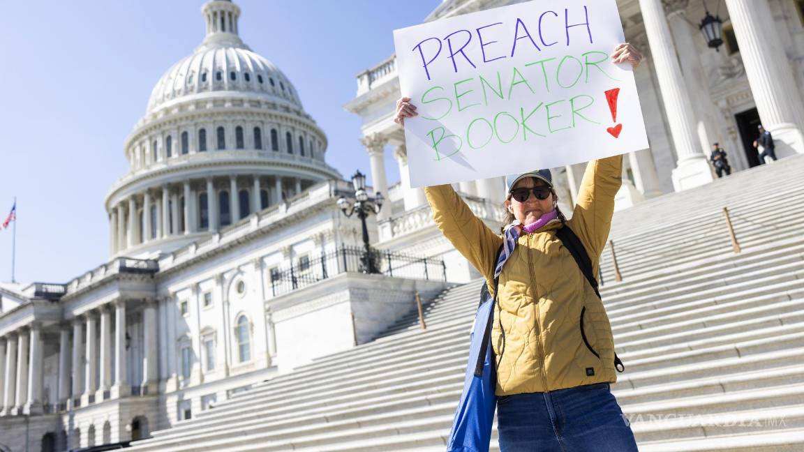 $!Susie Hodges sostiene un cartel en apoyo al senador demócrata Cory Booker, quien dio un discurso maratónico en el Senado contra las políticas de Trump.