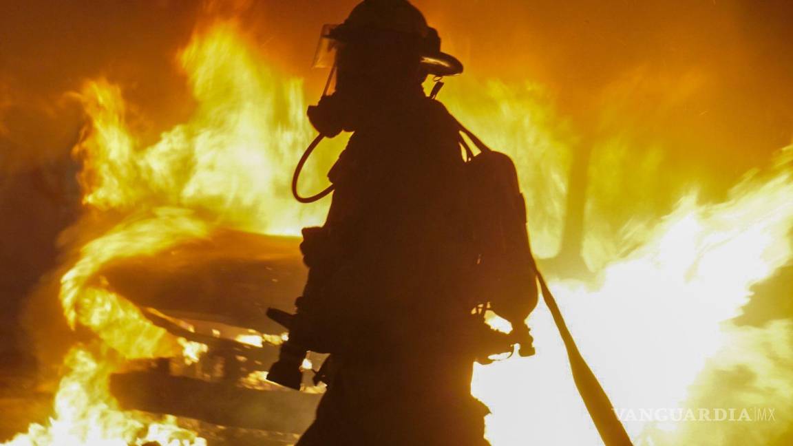 $!Bomberos sofocan las llamas de un vehículo incendiado en el centro de la ciudad.