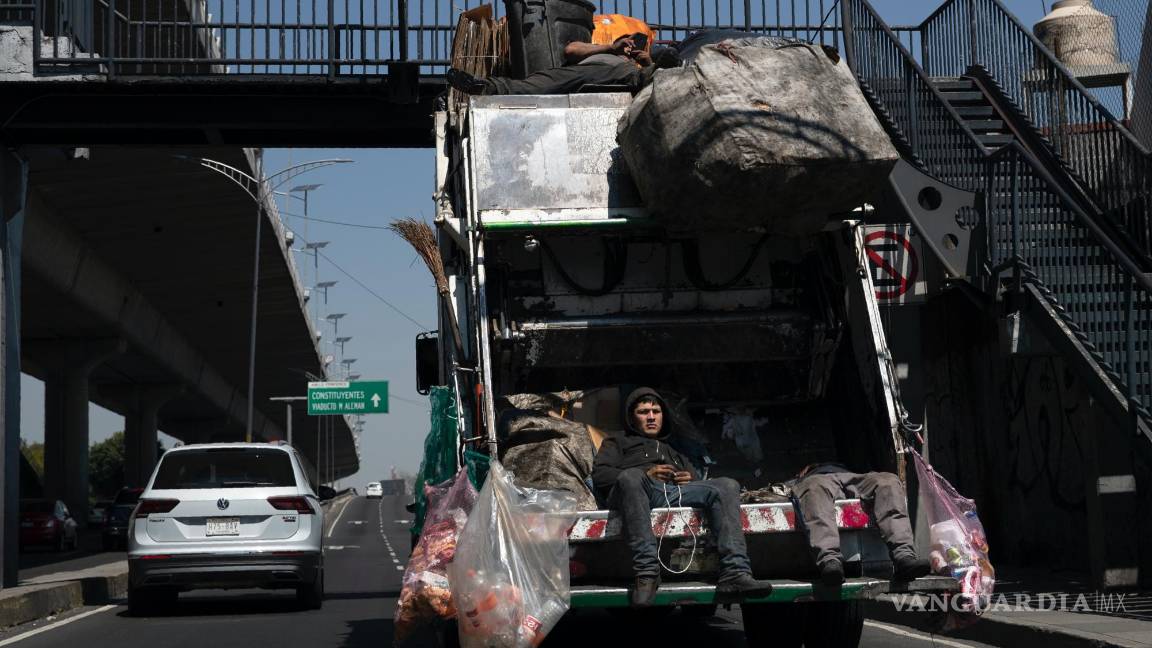 $!Recolectores de basura viajan en su camión de basura en la Ciudad de México, el martes 6 de octubre de 2020.